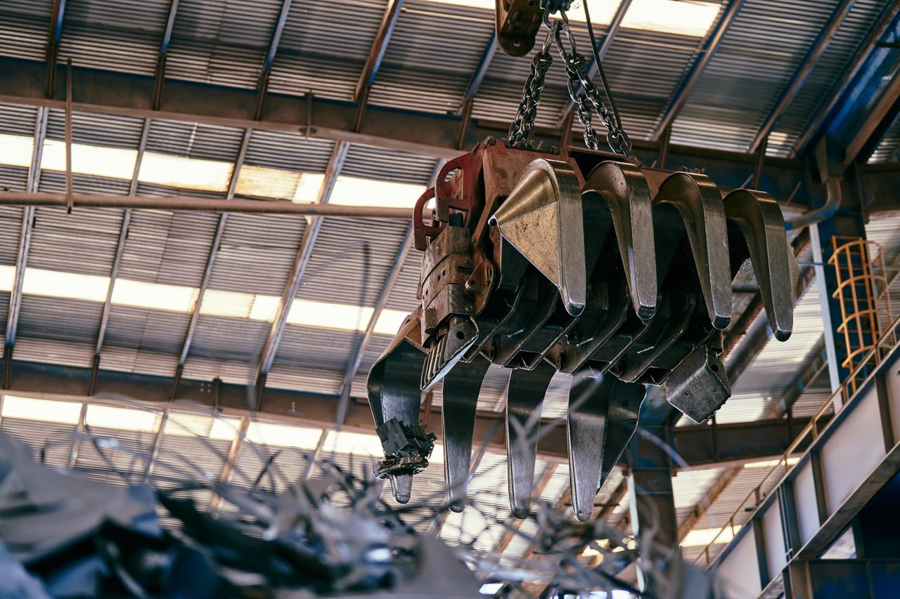 services-03 Large industrial crane handling scrap metal in a warehouse setting.