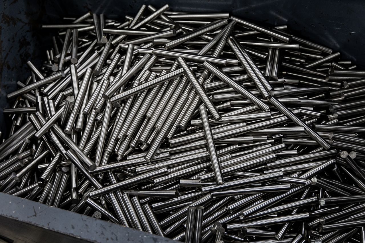 mission-02 Close-up of numerous stainless steel rods in a container, showcasing industrial metal texture.